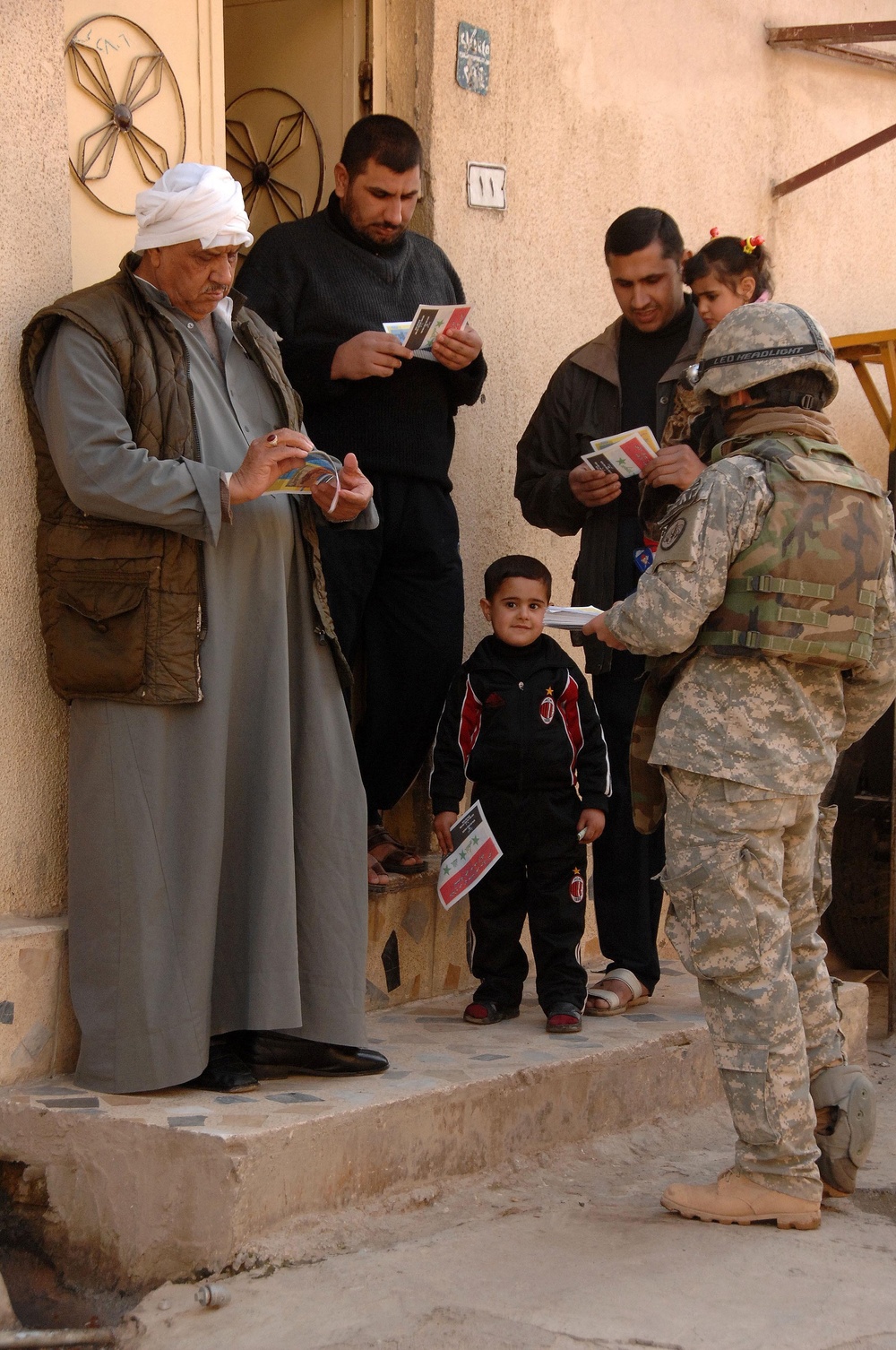 Soldier passes out wanted posters to locals