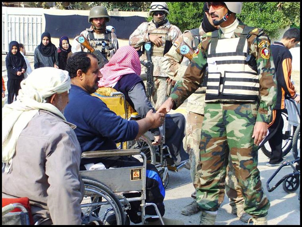 Iraqi Army Soldiers distribute wheelchairs in Schmook Village