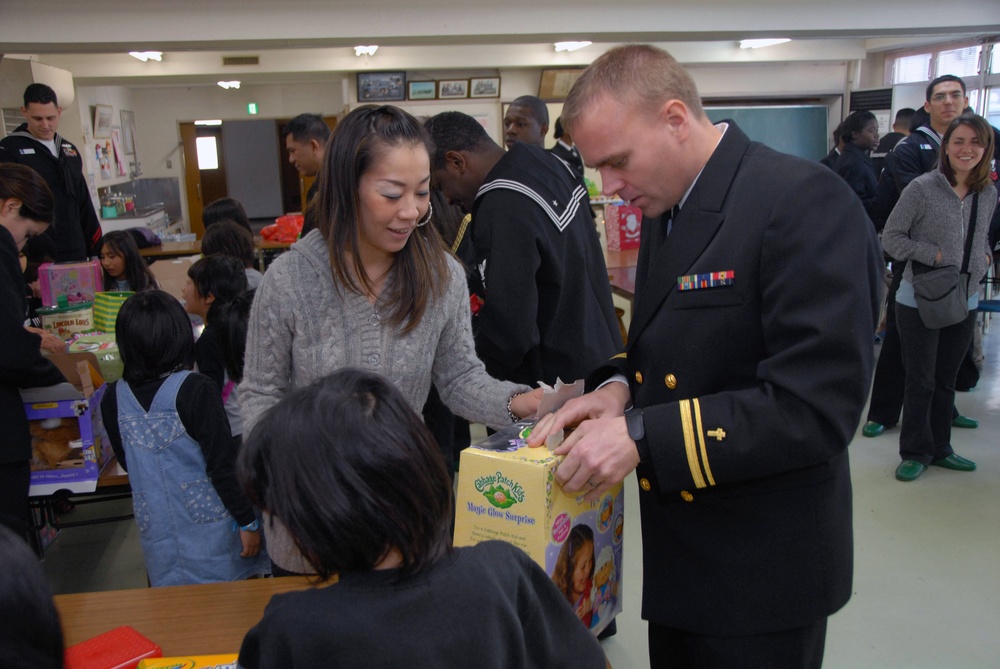 Lt. J.g. Steven T. Benefield Gives Gift to Child