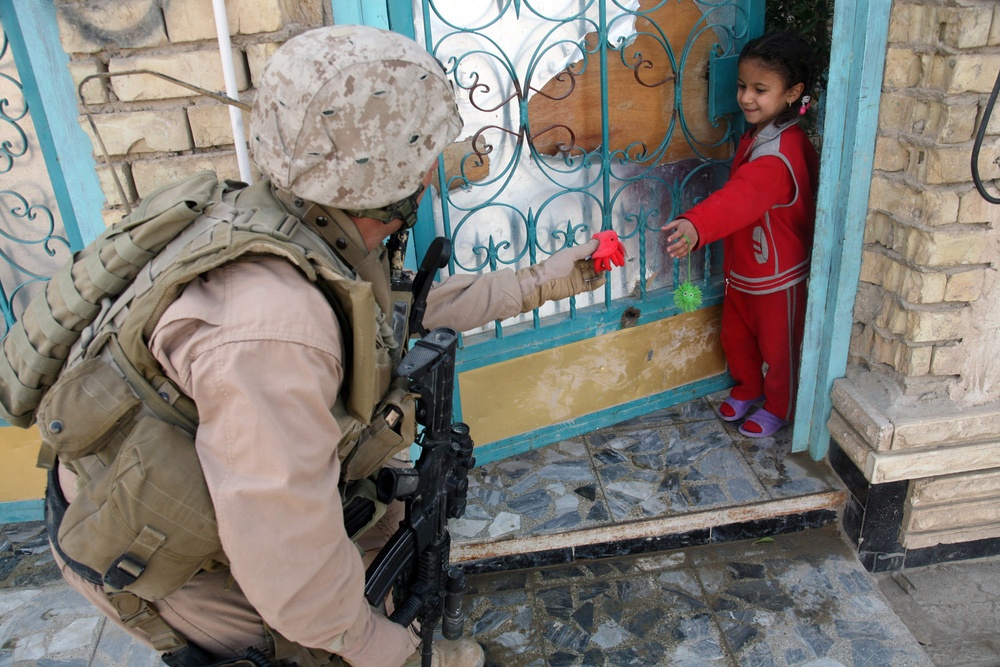 Capt. Rodrigo Cantu Hands an Iraqi Child a Toy