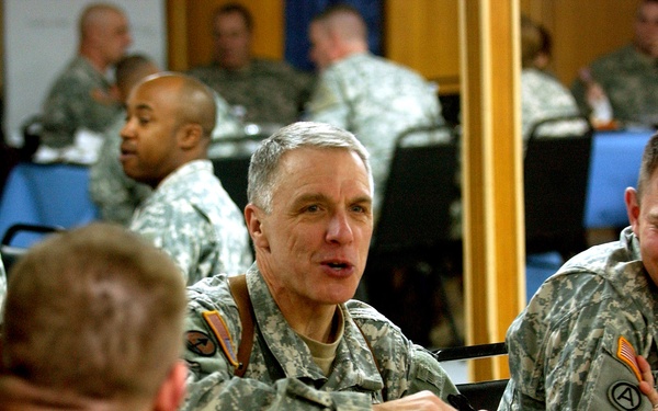 Maj. Gen. Robert Pollmann talks with service members