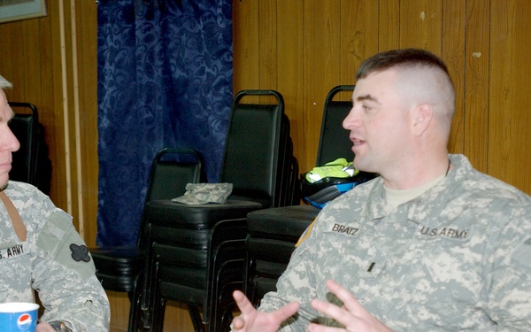Maj. Gen. Robert Pollmann talks with service members