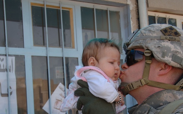 MND-B soldier shares tender moment with Iraqi child while on patrol