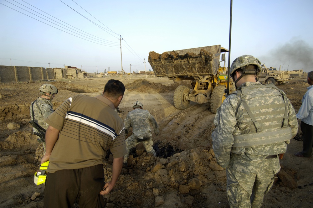 Soldier, Iraqi unearth weapons cache