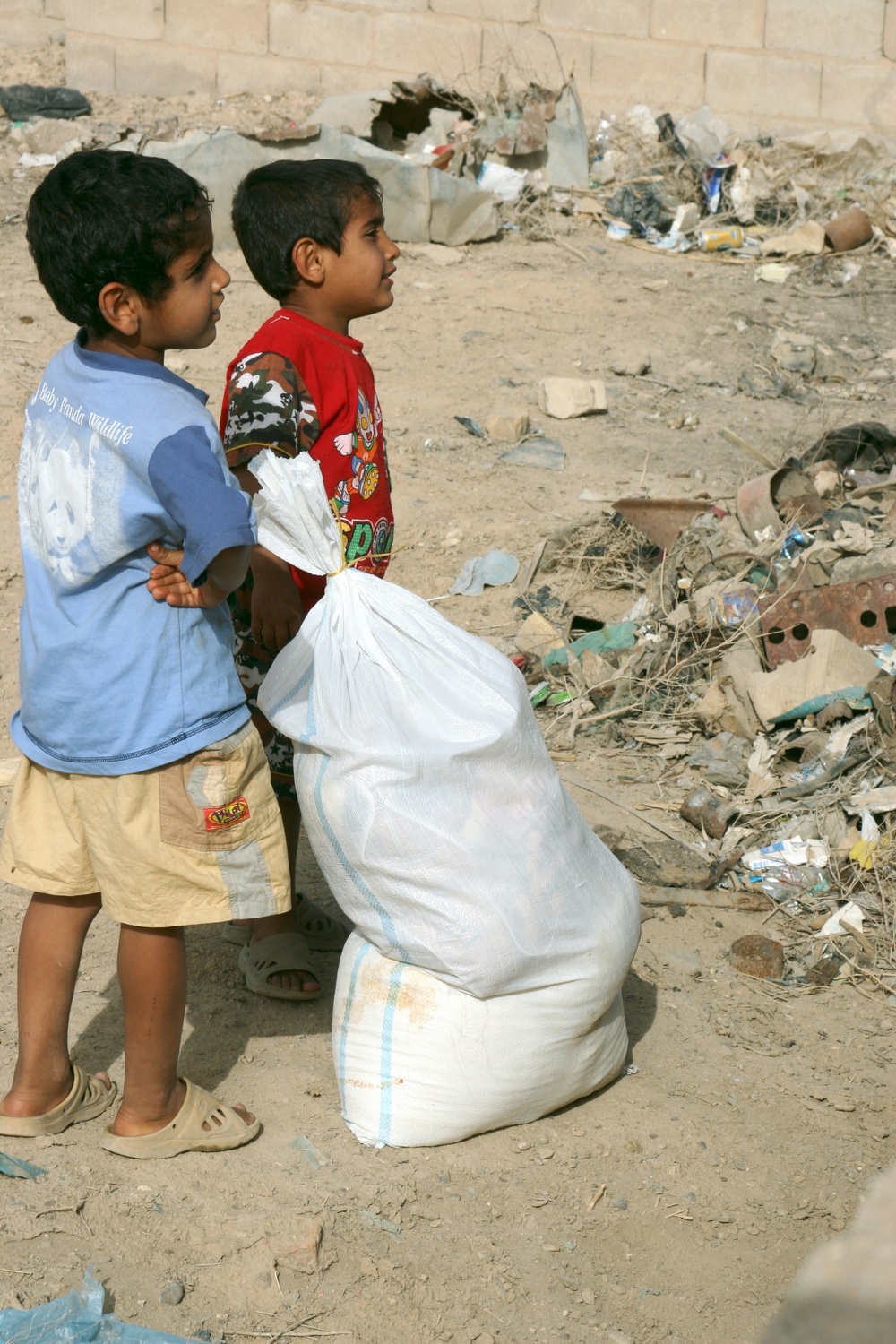 Iraqi policemen provide local needy families with free food bags