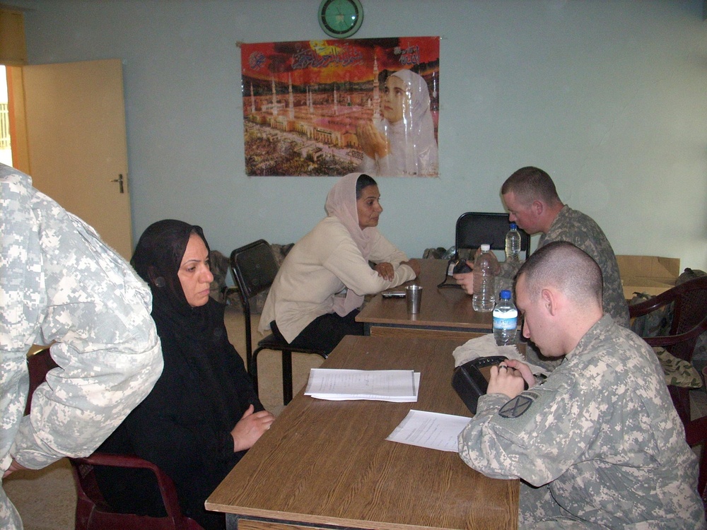 Field Artillery Soldiers process 75 new Sons, Daughters of Iraq