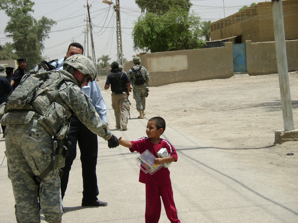 Soldiers, Iraqi Police Provide Pens, Smiles to Local Children