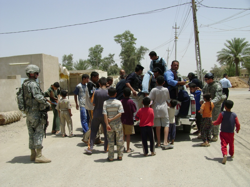 Soldiers, Iraqi Police Provide Pens, Smiles to Local Children