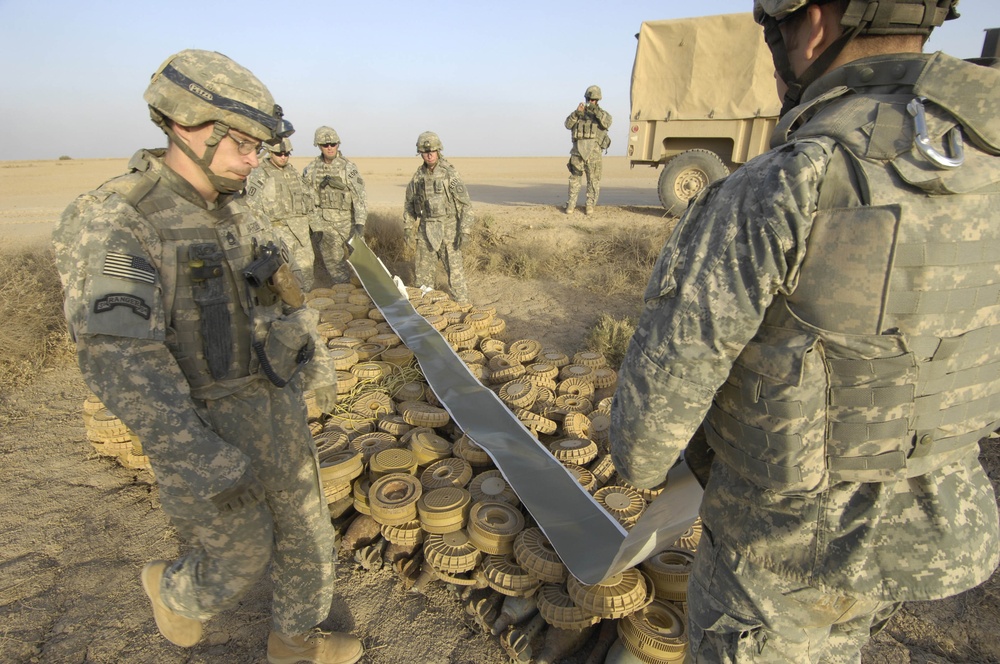 Soldiers prepare to destroy a cache of landmines