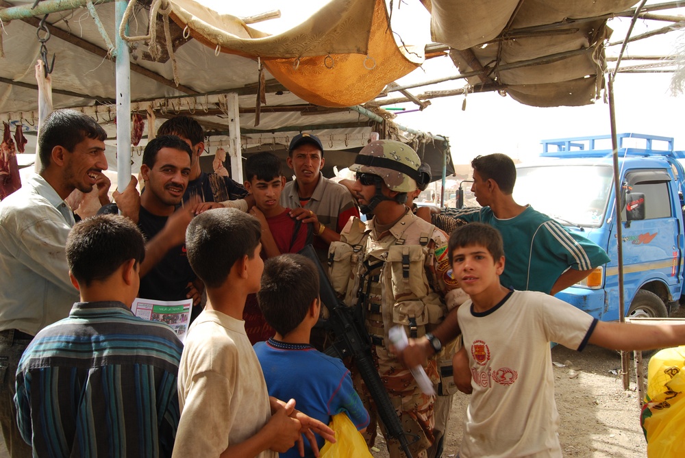 Iraqi army soldiers meet with locals at market