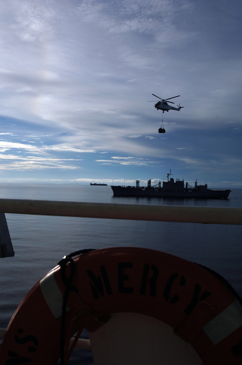Helicopter transfers supplies to USNS Mercy