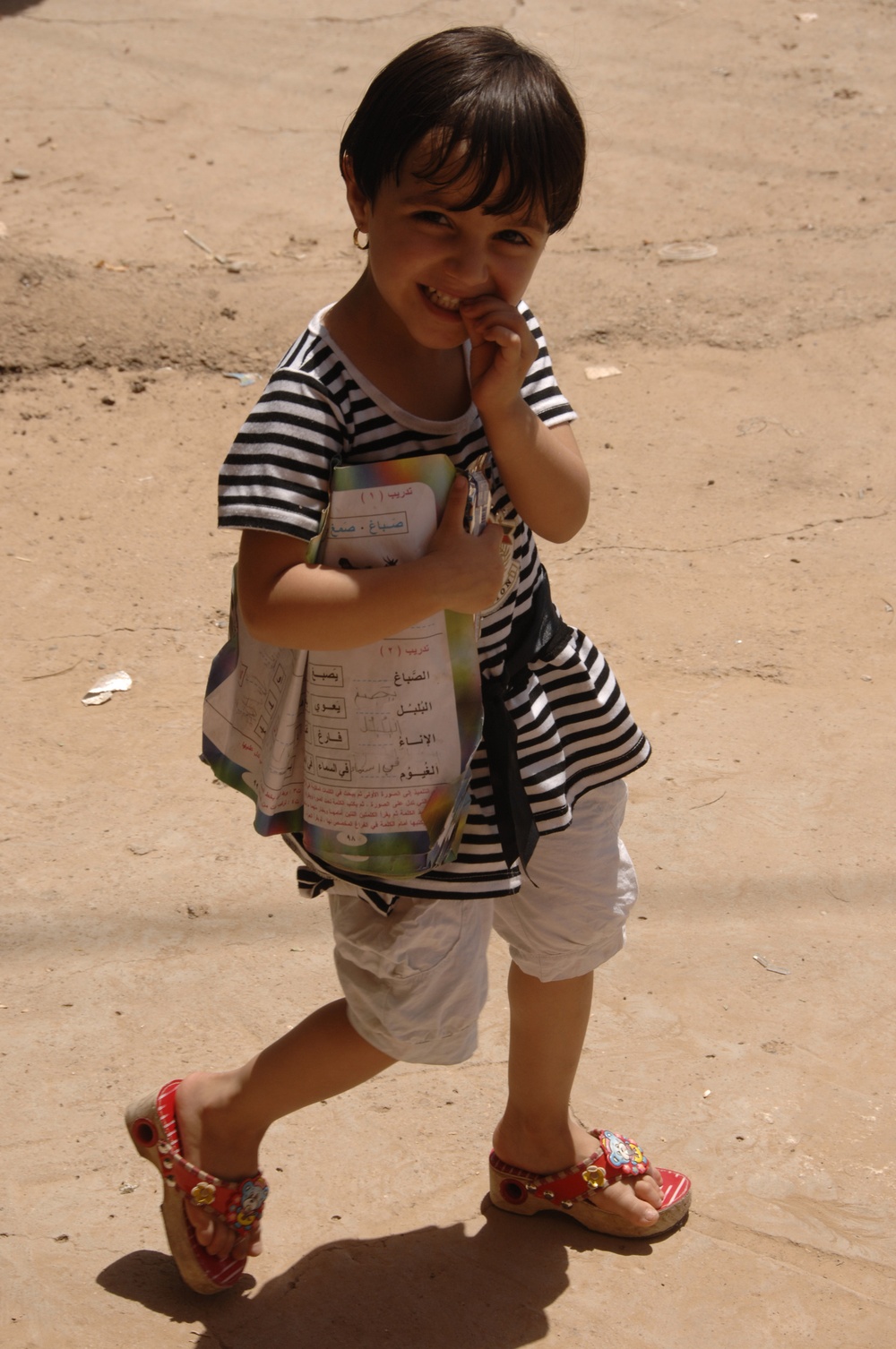 An Iraqi Child Smiles at Passing U.S. Soldiers