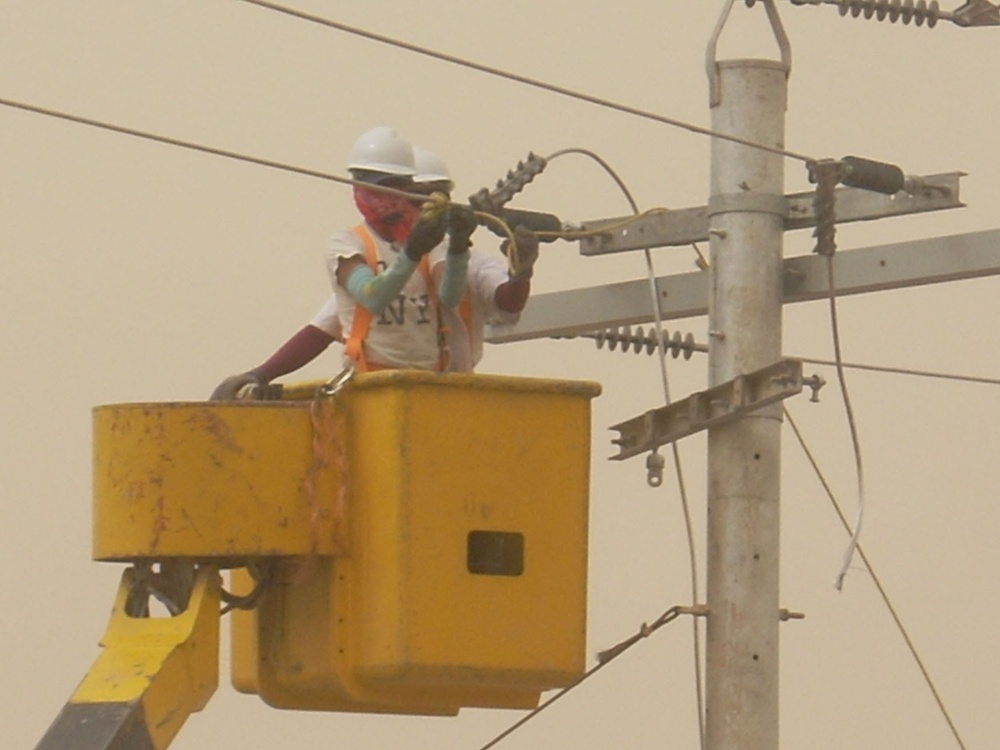 Local contract workers install power lines at Forward Operating Base Falcon