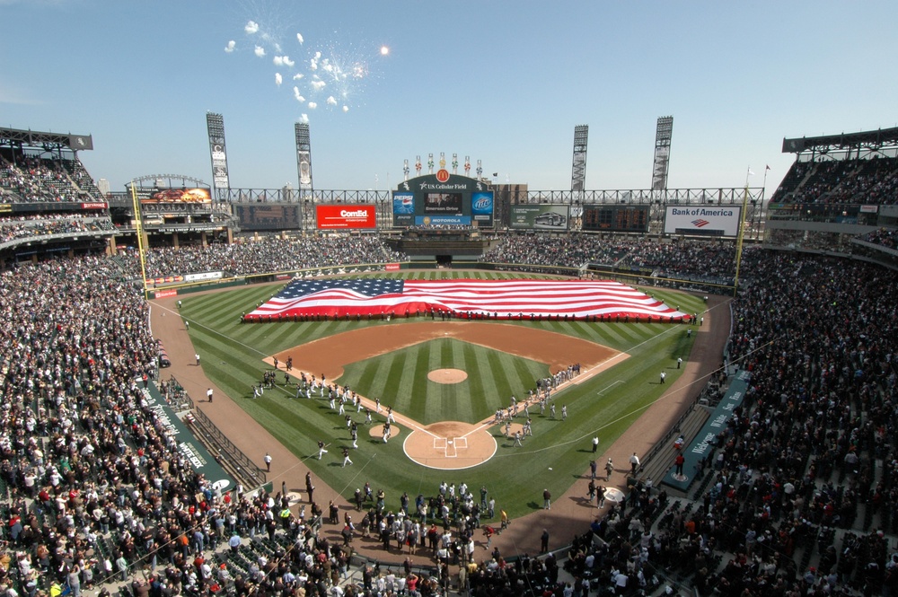 Sailors hold American flag at baseball game