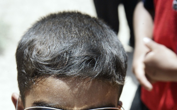 An Iraqi Child Waits in Line for Medical Treatment