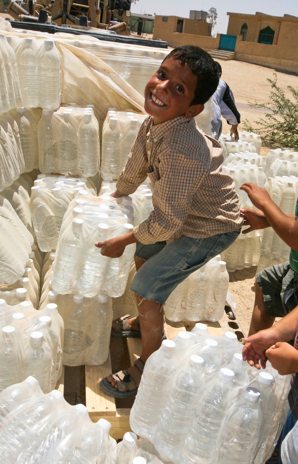 Iraqi Boys Help Move Bottled Water During Women's Engagement