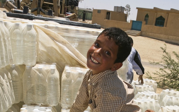 Iraqi Boys Help Move Bottled Water During Women's Engagement