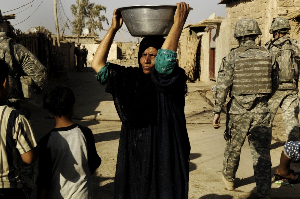 U.S. Soldiers Pass Out Pamphlets During Foot Patrol
