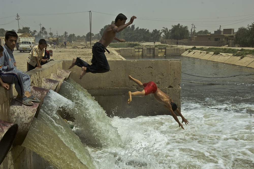 Iraqi Boys Play in Water From New Pumping Station