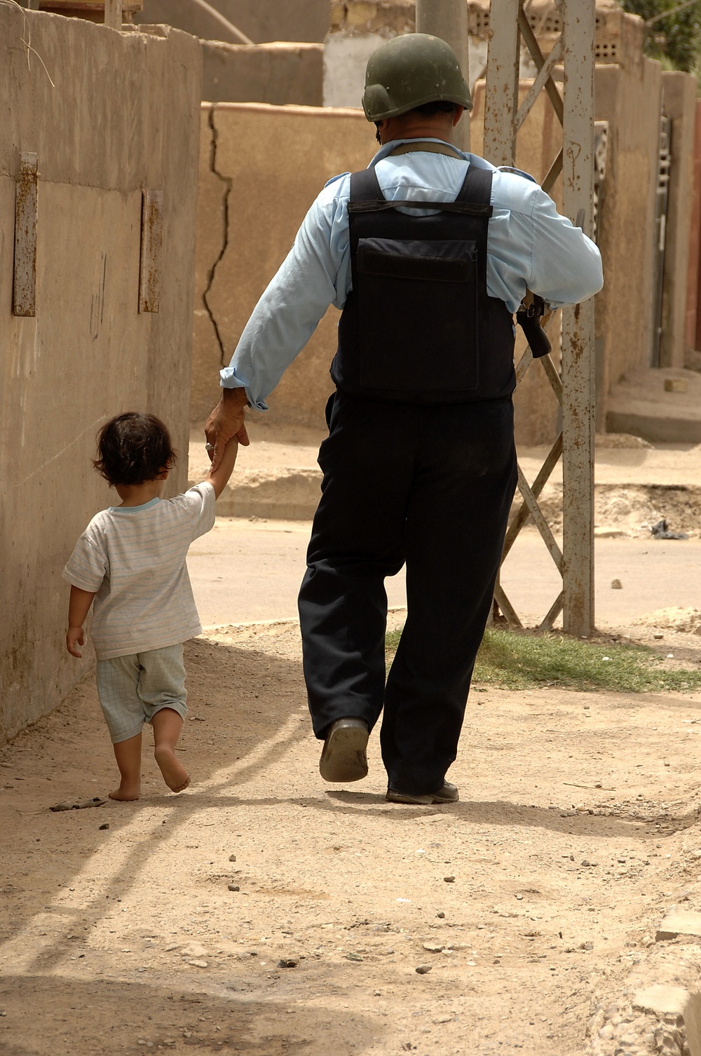 Iraqi Police Officer Escorts Small Child Home