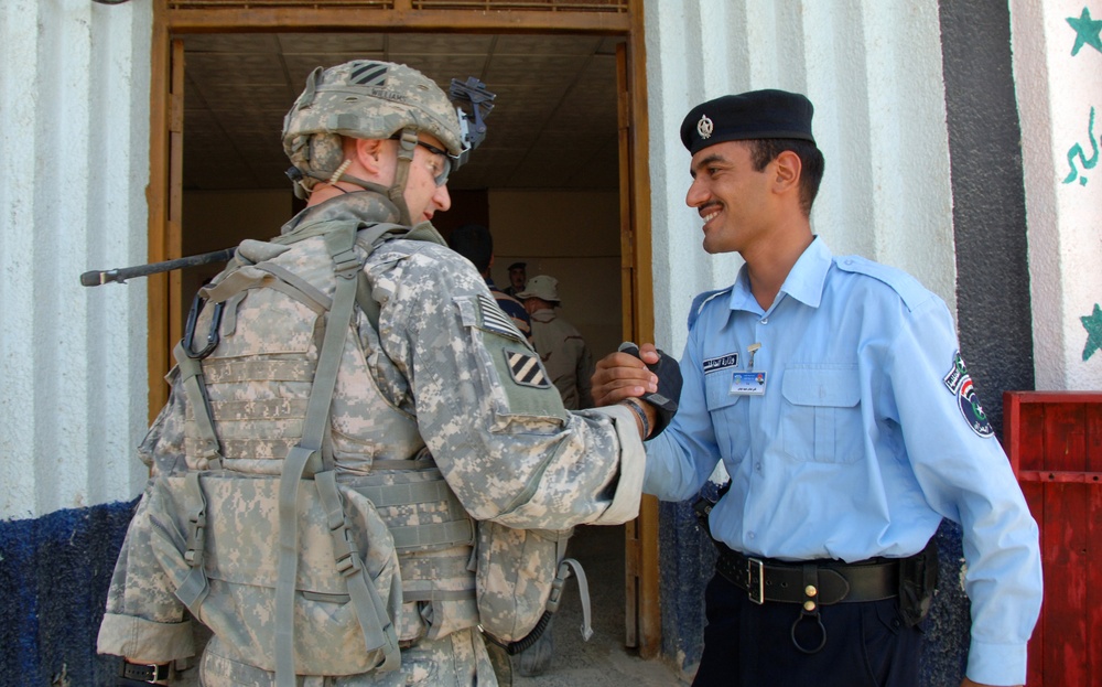 U.S. Soldier and Iraqi Policeman Happily Greet