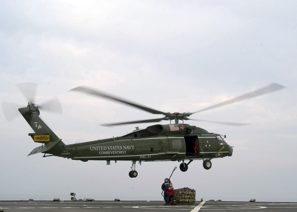 Sailors load helicopter during resupply