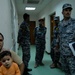 U.S. Soldiers, Iraqi Police Exam Iraqi Civilians
