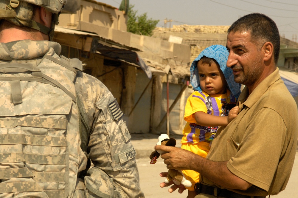 U.S. Soldiers hand out stuffed animals