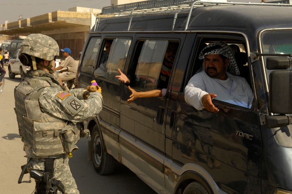 U.S. Soldiers hand out stuffed animals