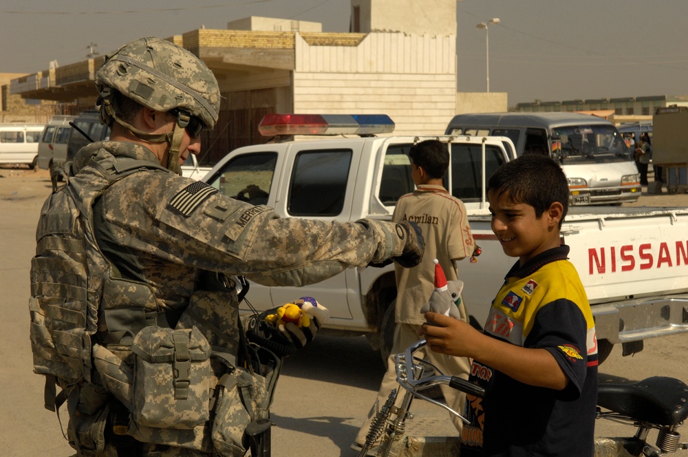 U.S. Soldiers hand out stuffed animals