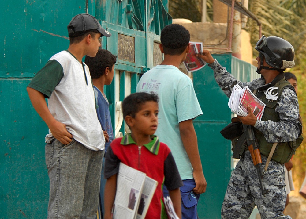 Iraqi national police hand out leaflets