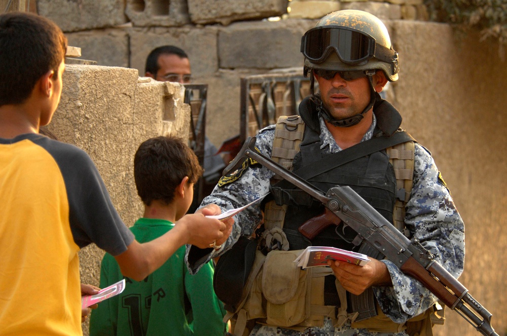 Iraqi national police hand out leaflets