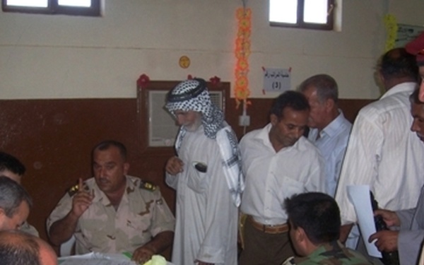 Former Iraqi military members are processed back into the military