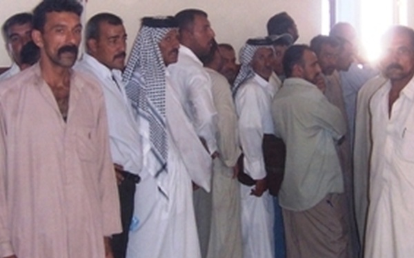 Former Iraqi military members are processed back into the military