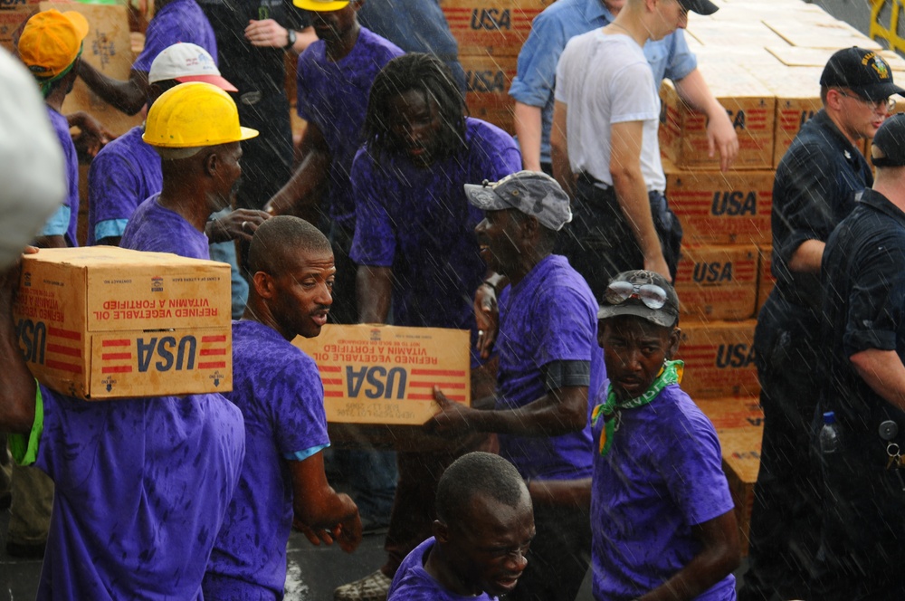 USS Kearsarge service members, Haitian citizens load hurricane relief supplies
