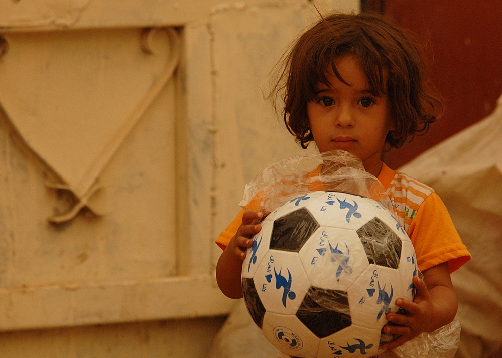 U.S. Soldiers pass out soccer balls
