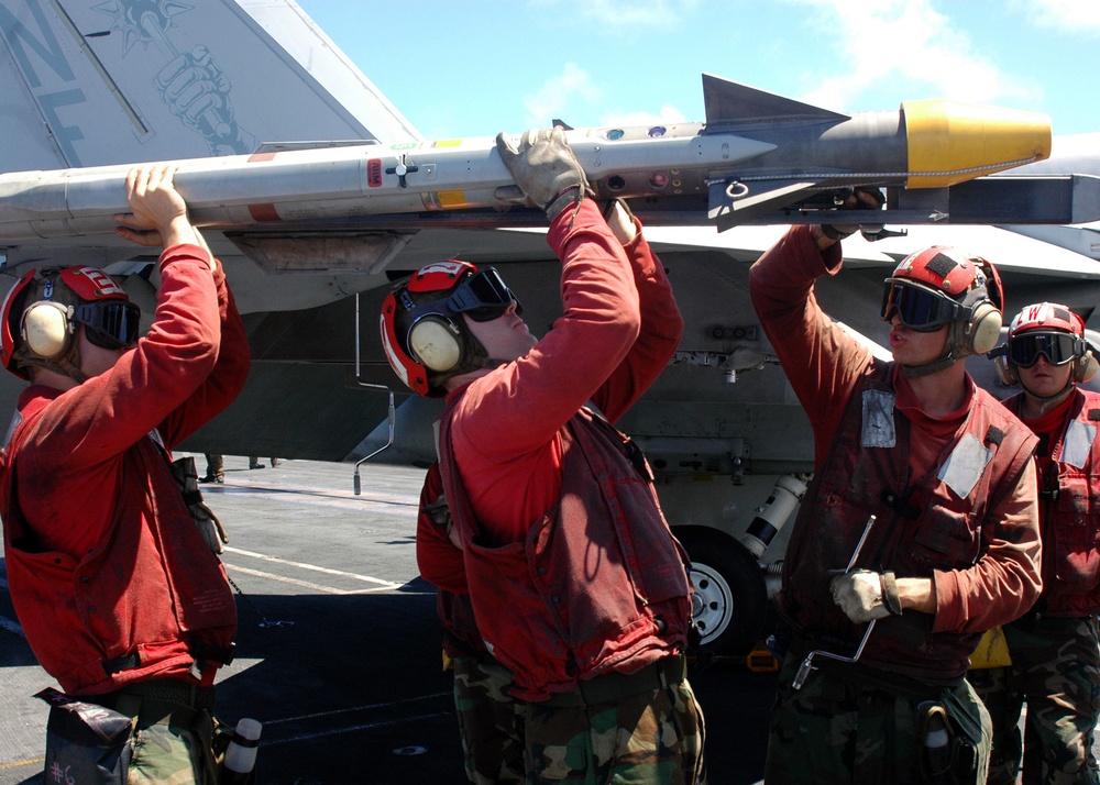Sailors detach missile from Super Hornet aboard USS George Washington