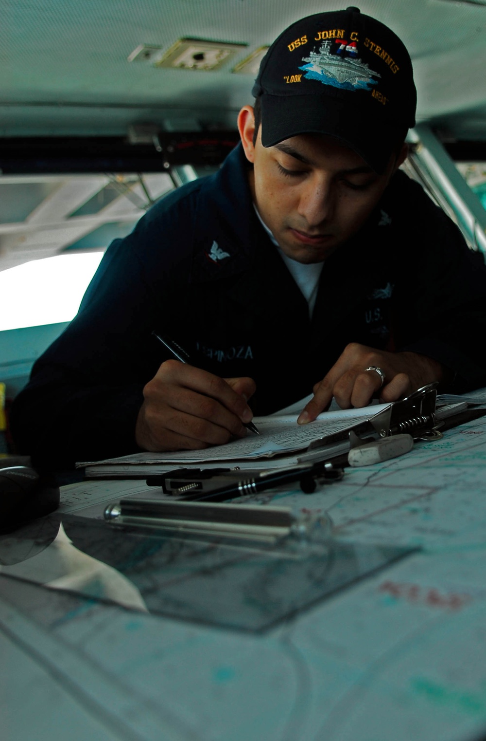 Seaman makes a ship's positional fix entry aboard USS John C. Stennis