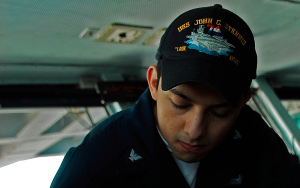 Seaman makes a ship's positional fix entry aboard USS John C. Stennis