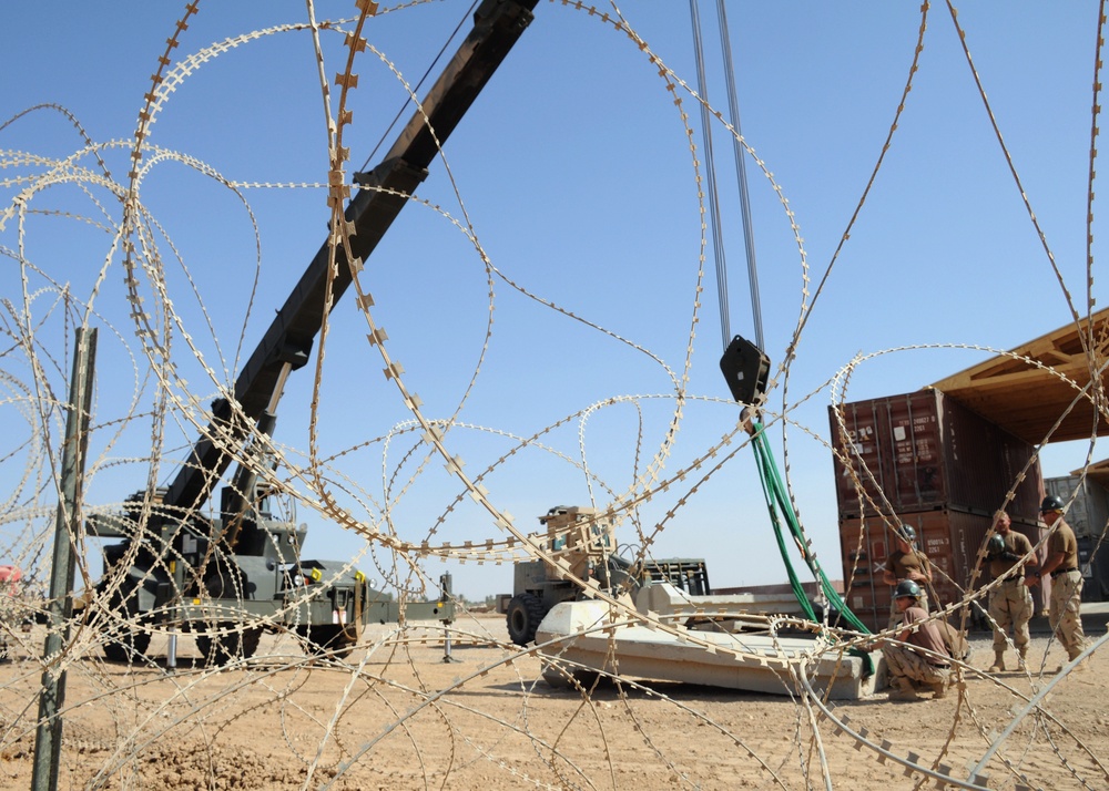 Seabees erect concrete barrier for new motor pool