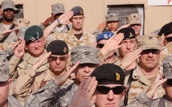 Service members of U.S. and coalition forces assigned to Combined Security Transition Command - Afghanistan stand at attention during the singing of the national anthem during the Veterans Day ceremony at Camp Eggers in Kabul, Nov. 11, 2008. More than 200