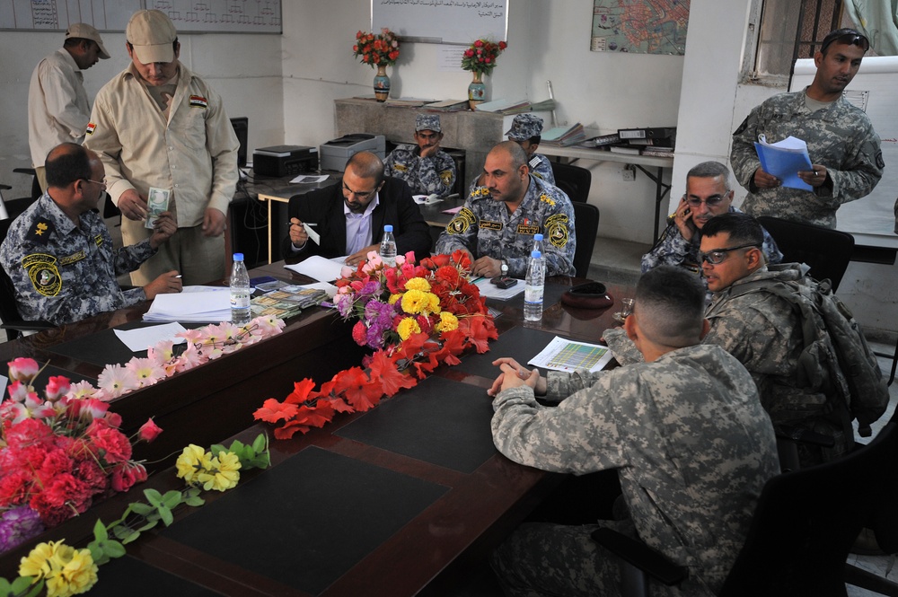 Iraqi national police distribute paychecks to Sons of Iraq
