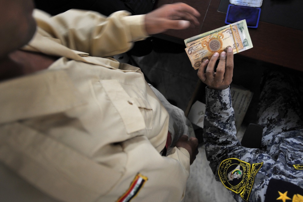 Iraqi national police distribute paychecks to Sons of Iraq