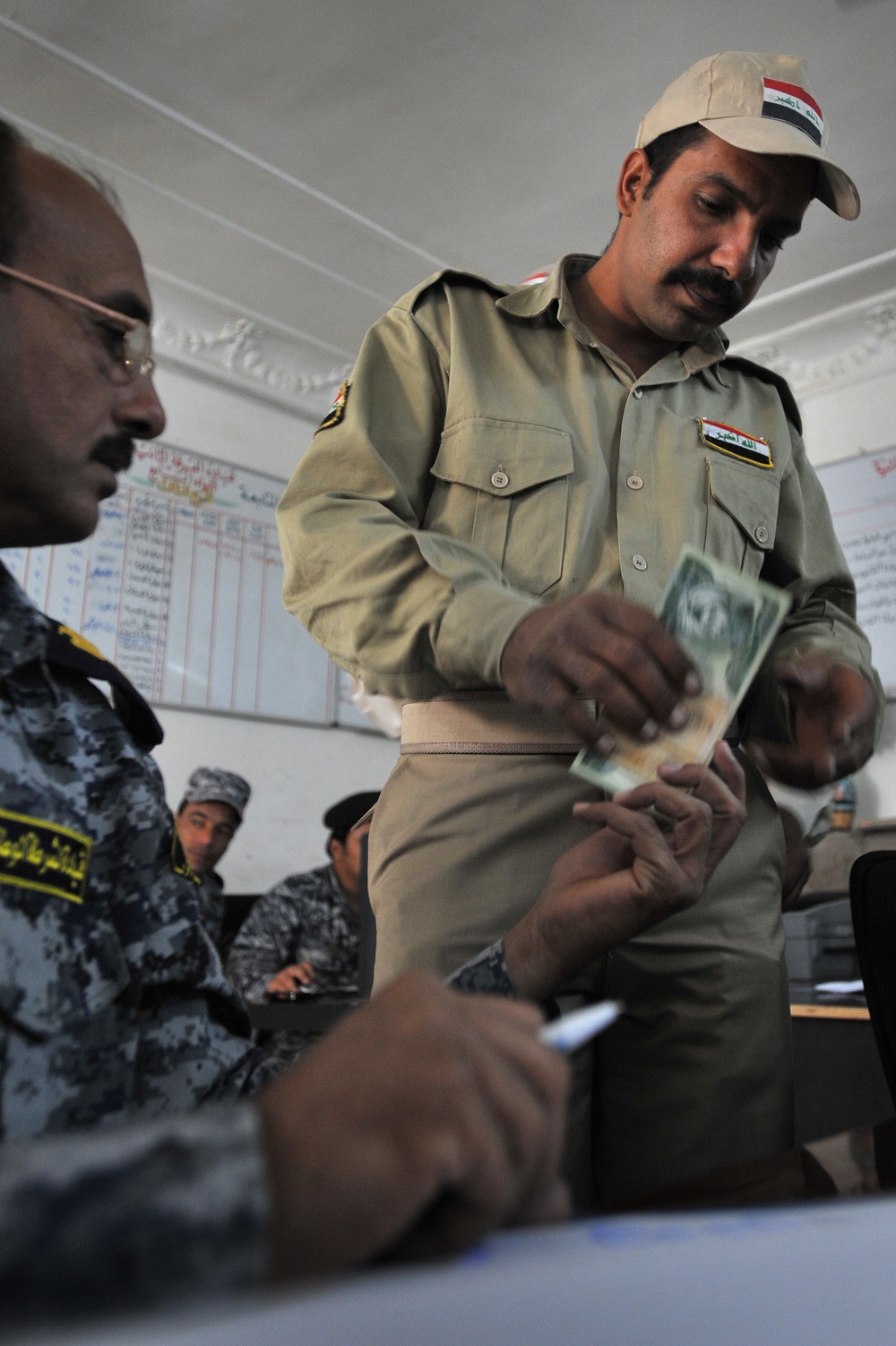 Iraqi national police distribute paychecks to Sons of Iraq