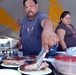 David Manzano plates up a sample of his team's grilled pork ribs to submit for U.S. Naval Station Guantanamo Bay's Morale, Welfare and Recreation Veterans Day Barbecue Competition, Nov. 11. Teams from both the Naval Station and Joint Task Force Guantanamo