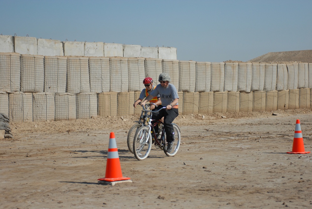 Colonel Italo Bastianelli (left), of West Point, N.Y., 41st Fires Brigade surgeon, catches up to Maj. Stanley Allen, 41st Fires Bde. chaplain, as the two compete in the last leg of the Forward Operating Base Delta Veterans Day Bike Race. Both teams -- six