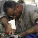 Soldiers perform maintenance on hydro booster oil line