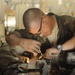 Soldiers perform maintenance on hydro booster oil line