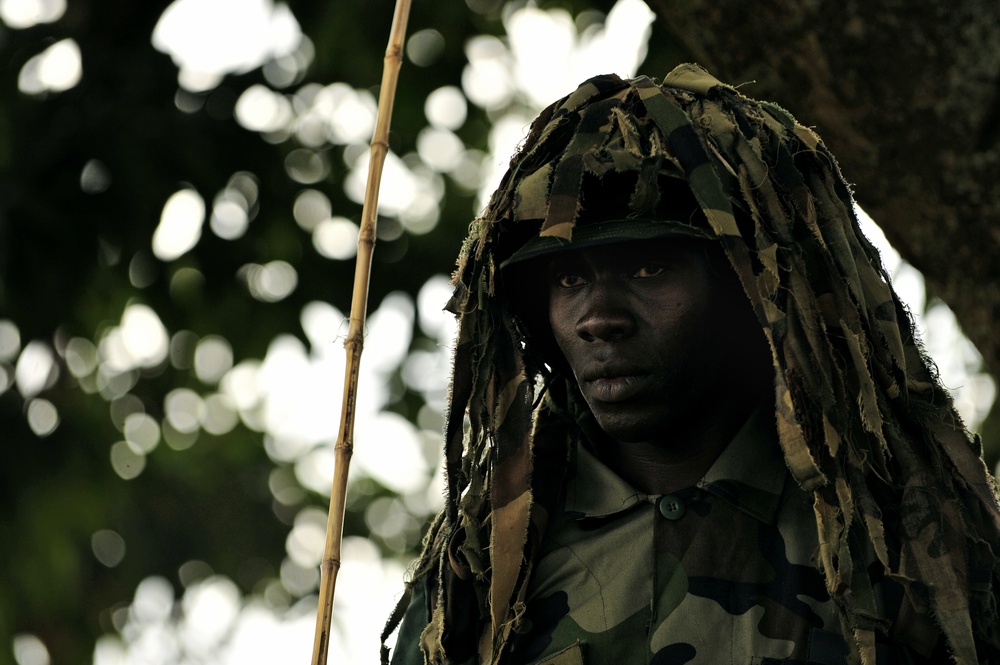 A Uganda Peoples Defense Force soldier Stands Beneath a Tree During a Demonstration of Skills Learned During the UPDF Non-Commissioned Officers Academy in Jinja.