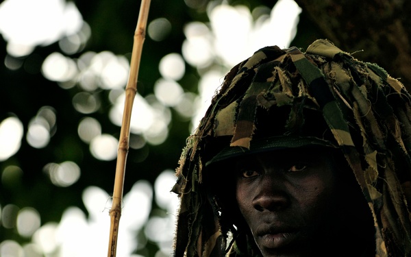 A Uganda Peoples Defense Force soldier Stands Beneath a Tree During a Demonstration of Skills Learned During the UPDF Non-Commissioned Officers Academy in Jinja.